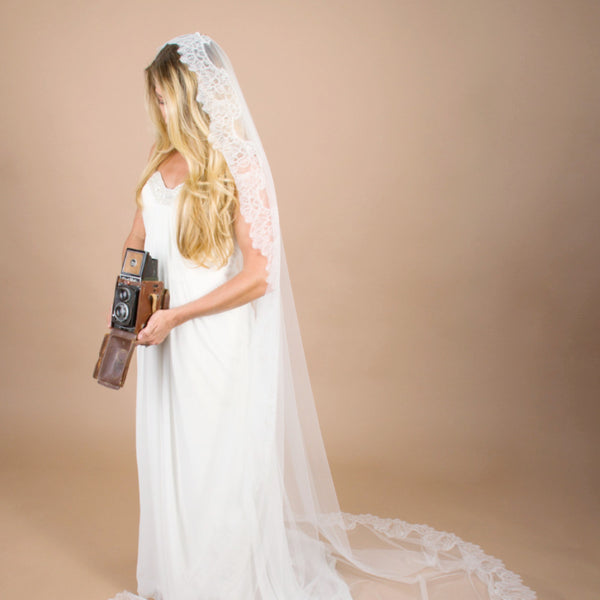 bride with vintage camera in mantilla veil